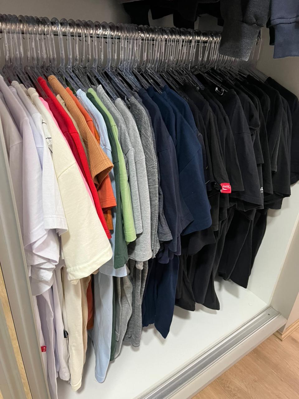 Roupas organizadas por gradiente de cor com cabides padronizados